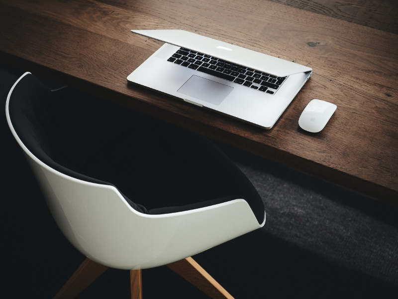 Bureau avec un ordinateur portable fermé face à une chaise