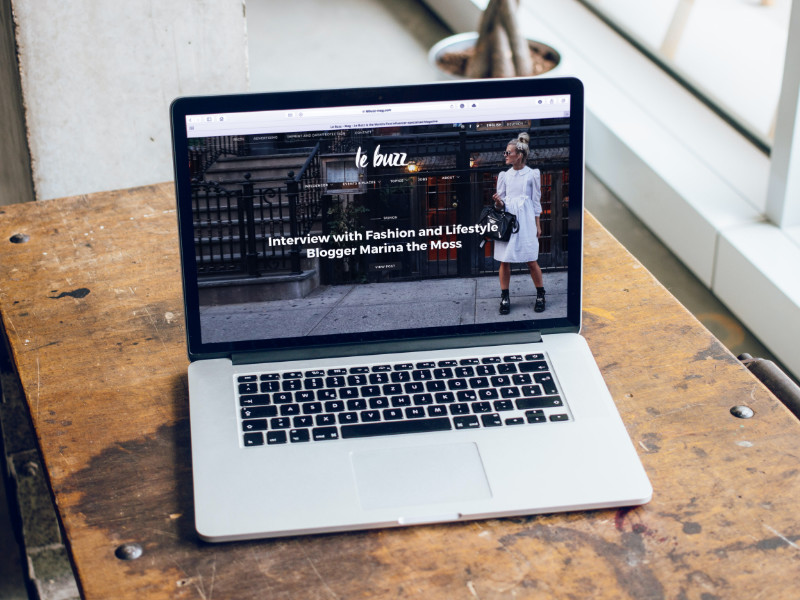 Mac ouvert sur un bureau avec un blog WordPress en fond d'écran